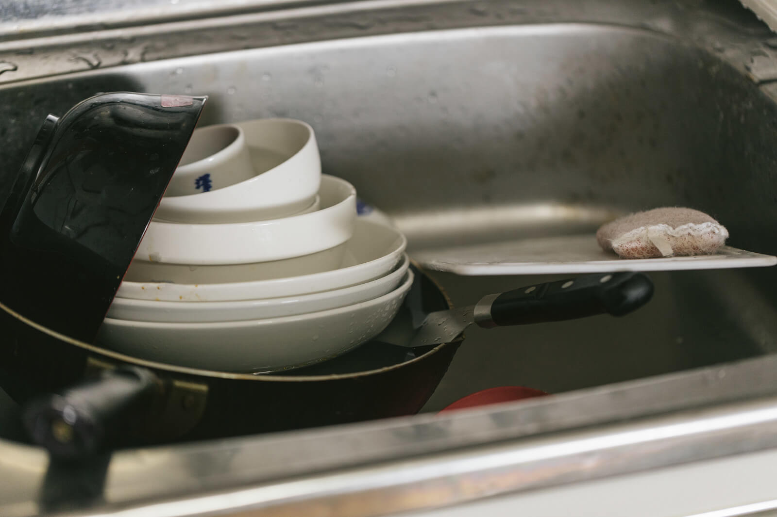 シンクに溜まった食器の画像